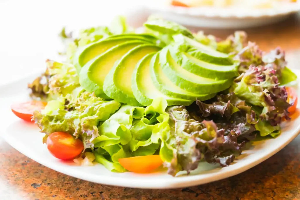 Fresh avocado salad with tomato, lettuce, and creamy avocado slices, perfect for a healthy meal.