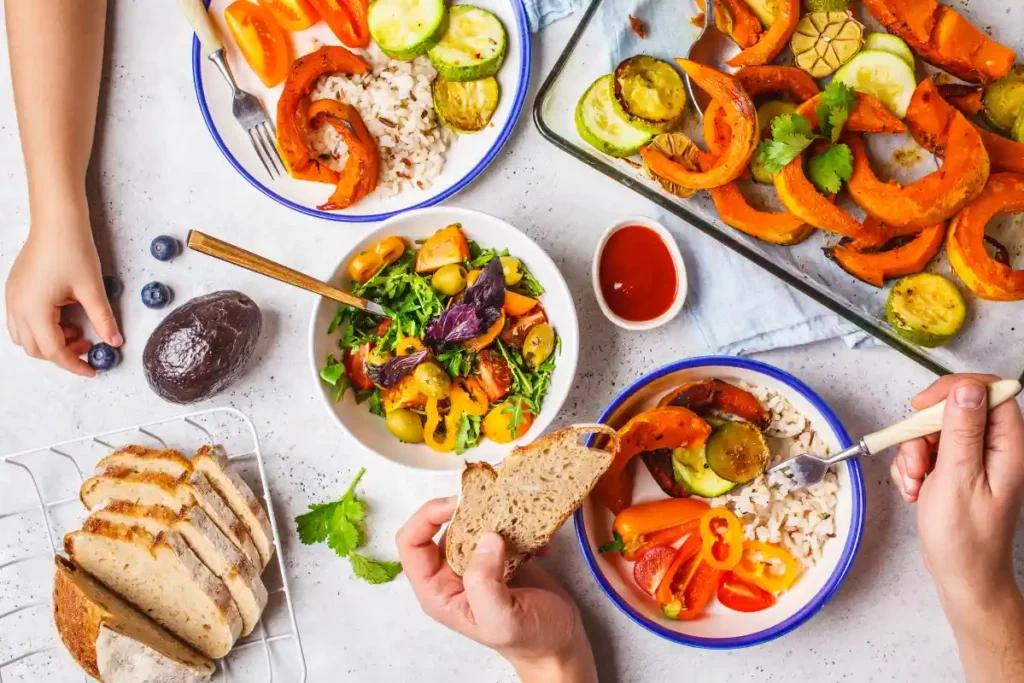 Family enjoying a healthy vegetarian meal together at the dining table, with colorful vegetables and plant-based dishes.