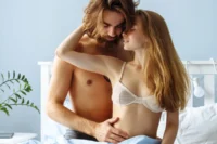 A couple lying on a bed, sharing a close and intimate moment, filled with affection and love.