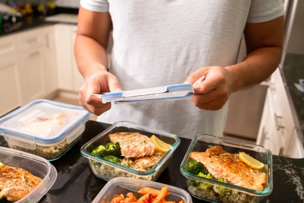 Man prepping salmon and placing it into lunch containers for the week’s meals.