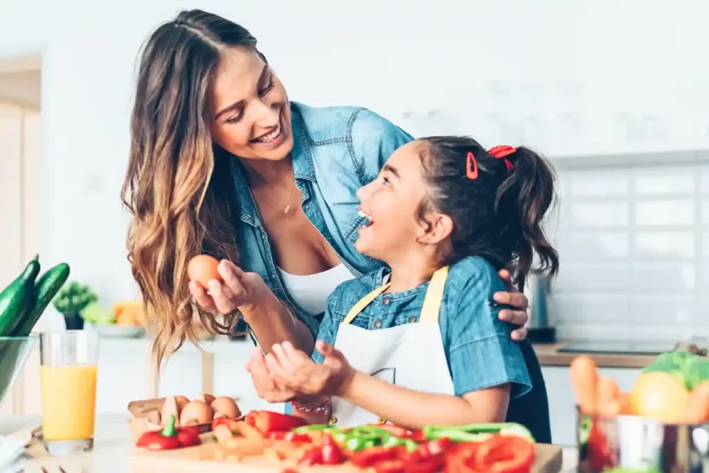 Mother and daughter preparing a healthy meal together in the kitchen, chopping fresh vegetables and enjoying quality time.
