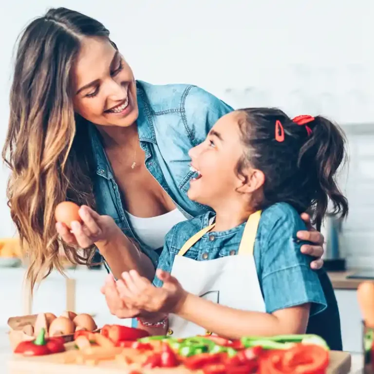 Mother and daughter preparing a healthy meal together in the kitchen, chopping fresh vegetables and enjoying quality time.