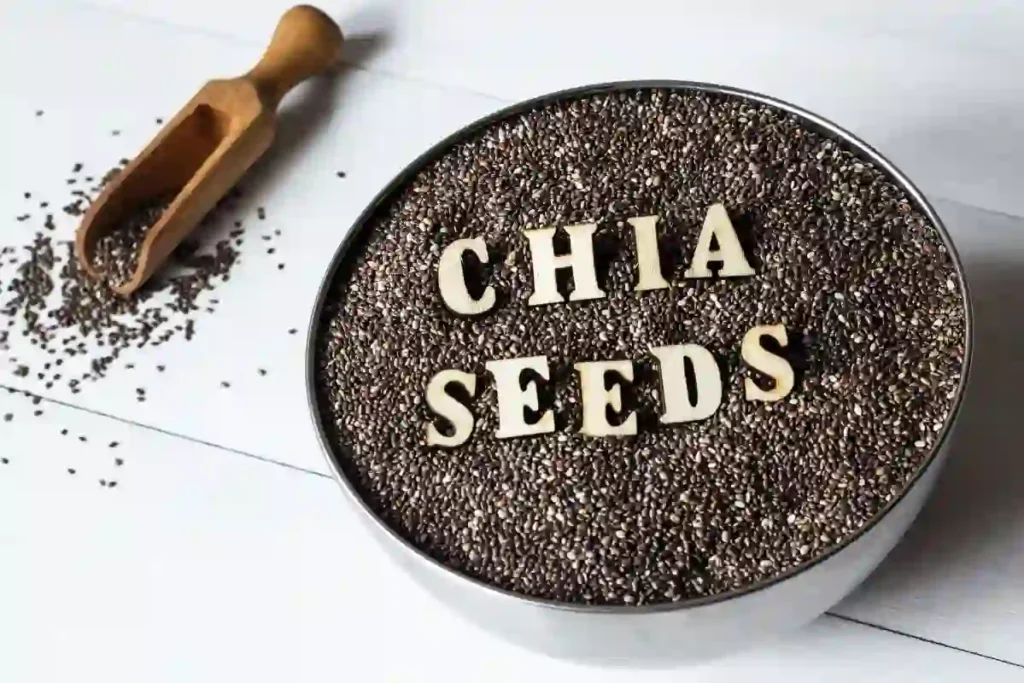 Chia seeds in a metal bowl with a scooper, ready to be used for a healthy meal or snack.
