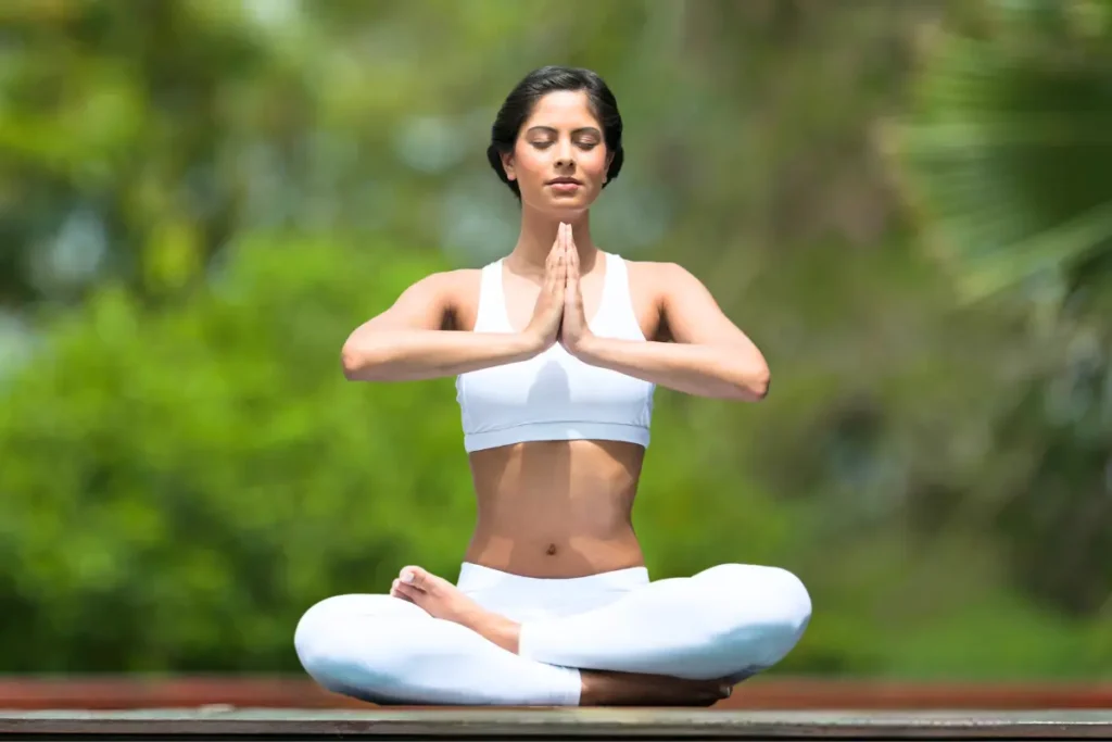 Woman practicing yoga in a garden, surrounded by nature, promoting peace and mindfulness.