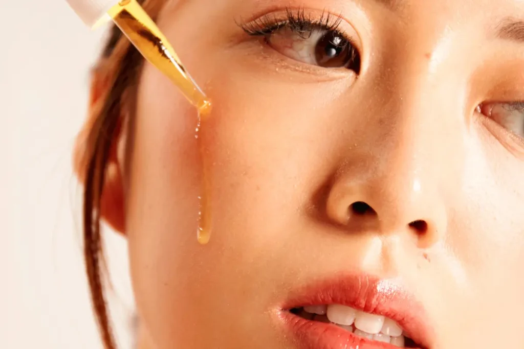 Woman applying serum as part of her skincare routine for a healthy complexion.