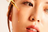 Woman applying serum as part of her skincare routine for a healthy complexion.