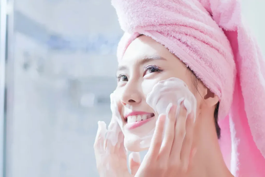 Woman washing her face in the bathroom as part of her skincare routine, cleansing and refreshing her skin.