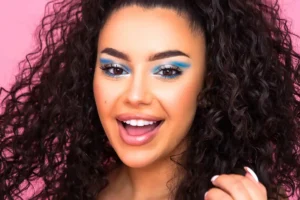 Woman showcasing bright eye makeup, enhancing her facial features.