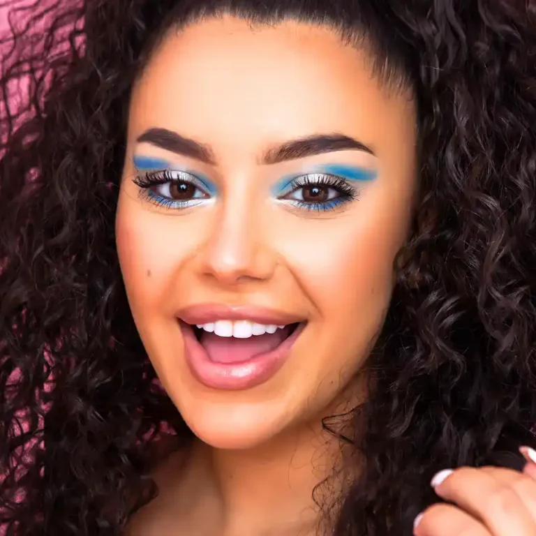 Woman showcasing bright eye makeup, enhancing her facial features.