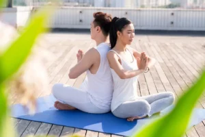 Couple practicing yoga on a rooftop of a building in the city, enjoying a peaceful moment with a skyline view.